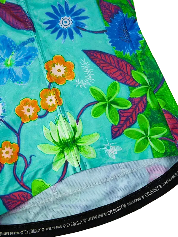 Vibrant floral cycling jersey with blue, orange, and green blooms on teal fabric, featuring branded hem
