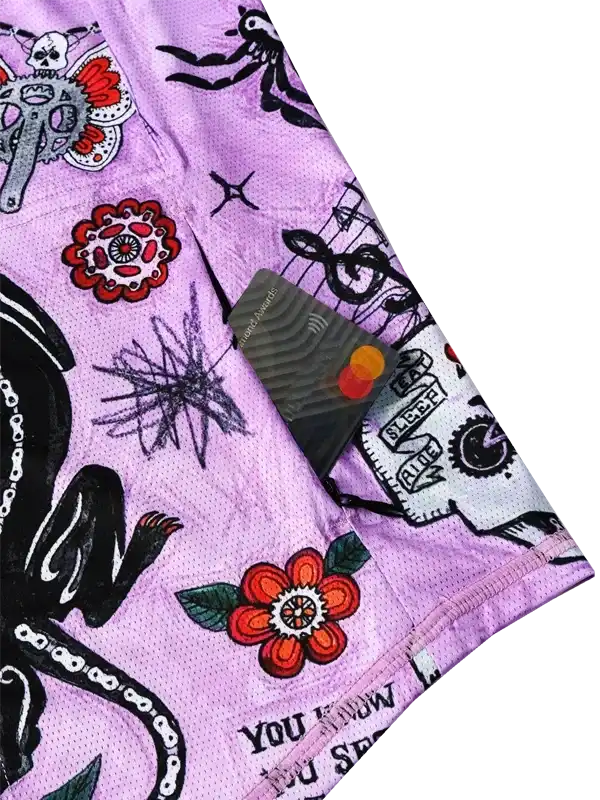 Purple cycling shorts with tattoo-style skull, flower, and octopus print, featuring mesh fabric and pocket detail.