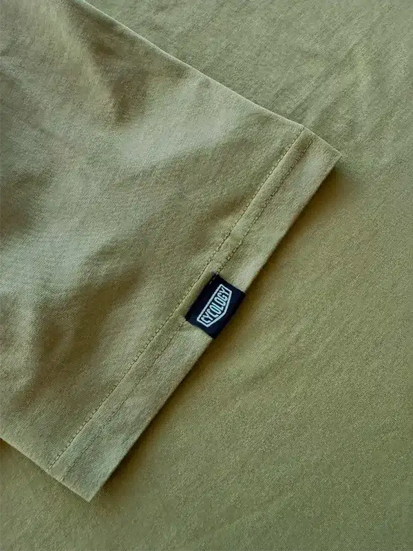 Olive green cycling jersey sleeve with black Cycology brand tag, showcasing quality fabric and stitching.