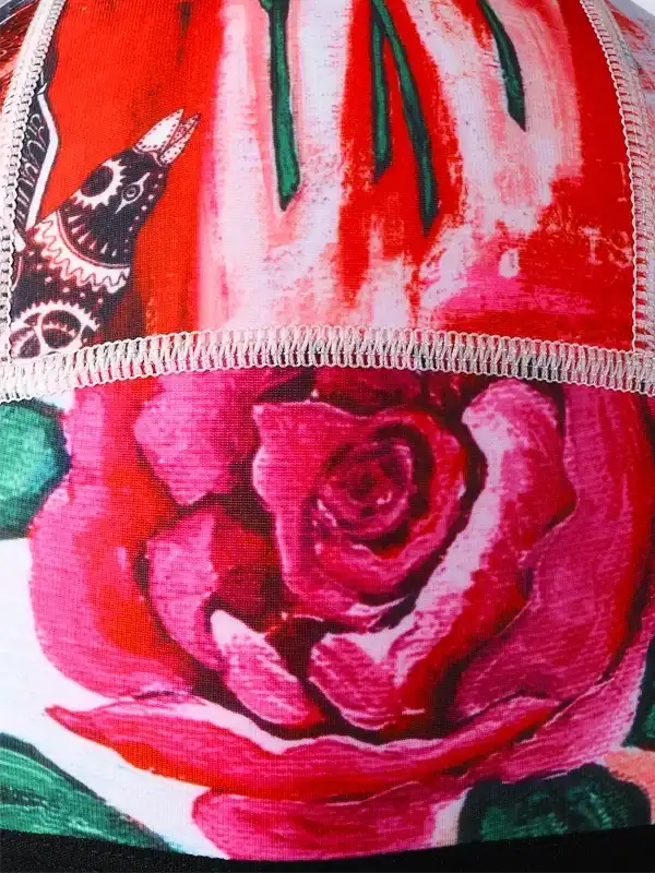 Vibrant red rose and bird print on cycling apparel fabric, showcasing unique design details.