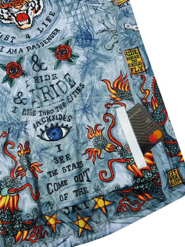 Close-up of a jersey with tattoo-style designs, text, and symbols on a blue background.