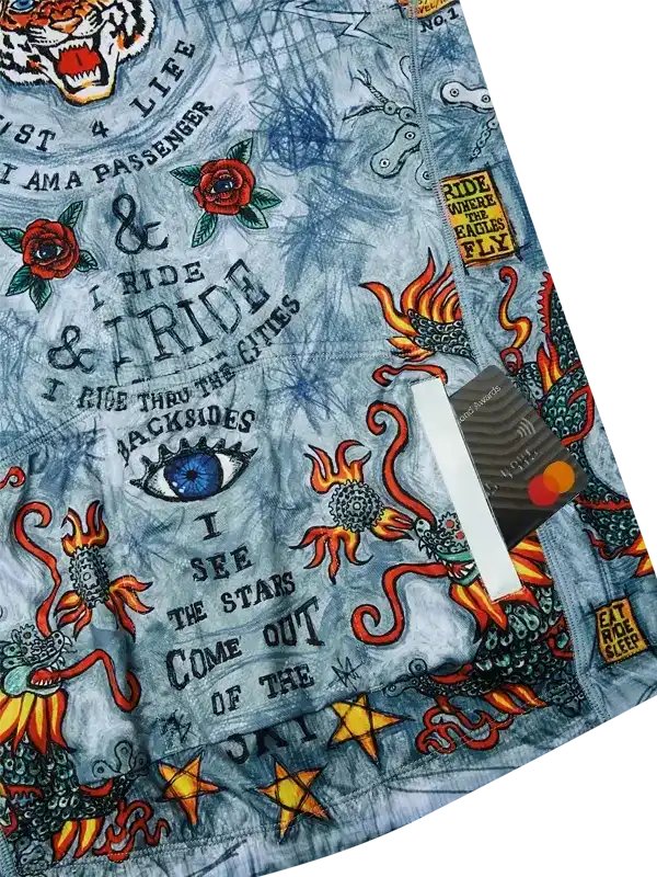 Men's cycling shorts with bold tattoo-style dragon, rose, and eye print, featuring motivational ride-themed text