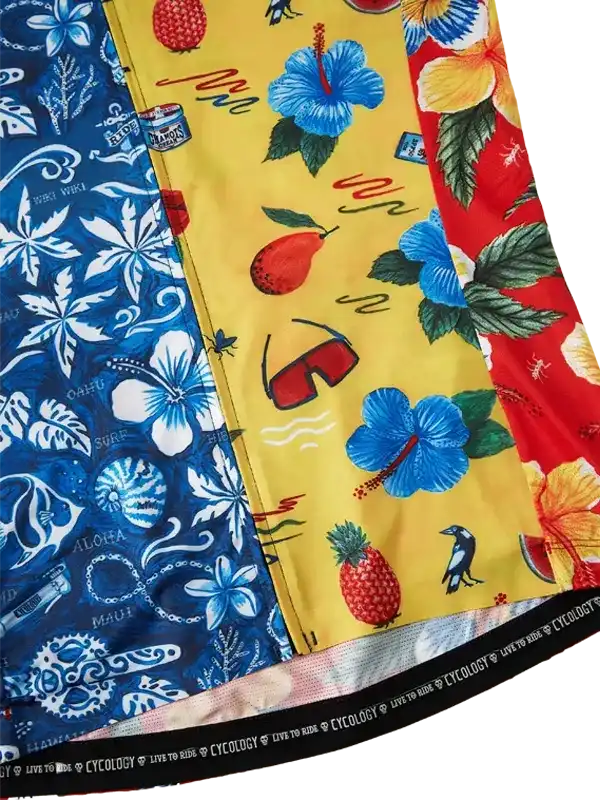 Vibrant tropical print cycling shorts with hibiscus, pineapple, and surf designs in blue, yellow, red