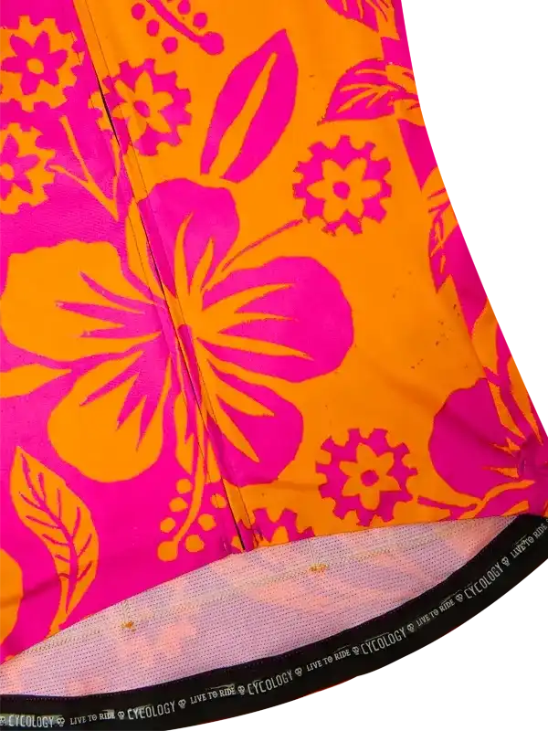 Vibrant pink and orange floral cycling jersey with bold hibiscus print and mesh hem detail
