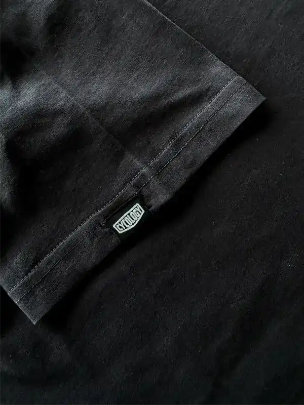 Black cycling jersey sleeve with branded tag, showcasing high-quality fabric and stitching detail