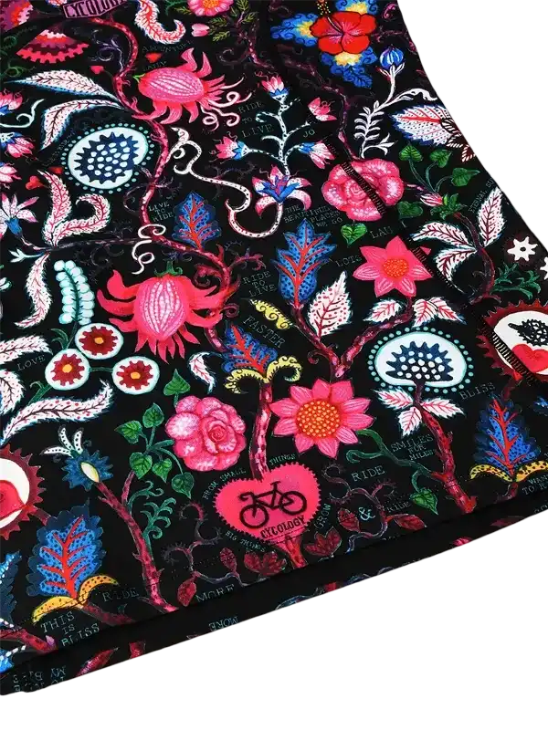Vibrant floral cycling apparel with bold pink, blue, and green patterns on black fabric
