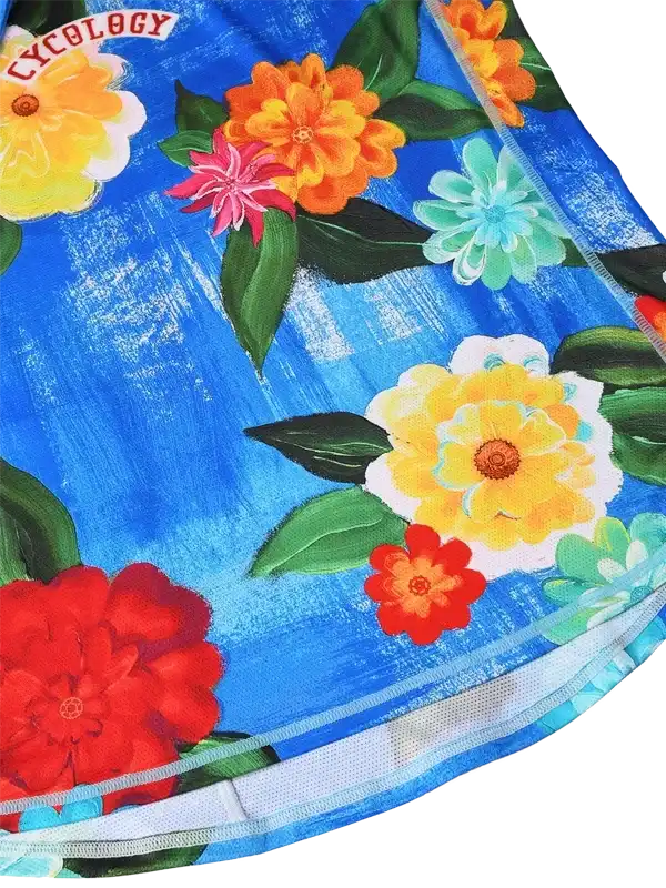Vibrant floral cycling jersey with bold blue background and colorful flowers, ideal for women's bike rides.