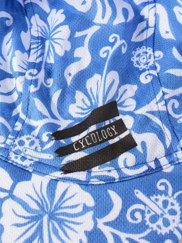 Blue and white floral cycling jersey with Cycology brand tag, featuring tropical hibiscus print and performance fabric.