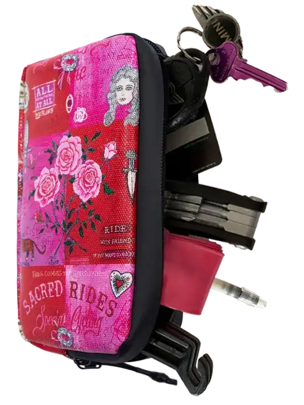 Pink floral cycling accessory pouch with keys, multitool, and tire lever, featuring 'Sacred Rides' design