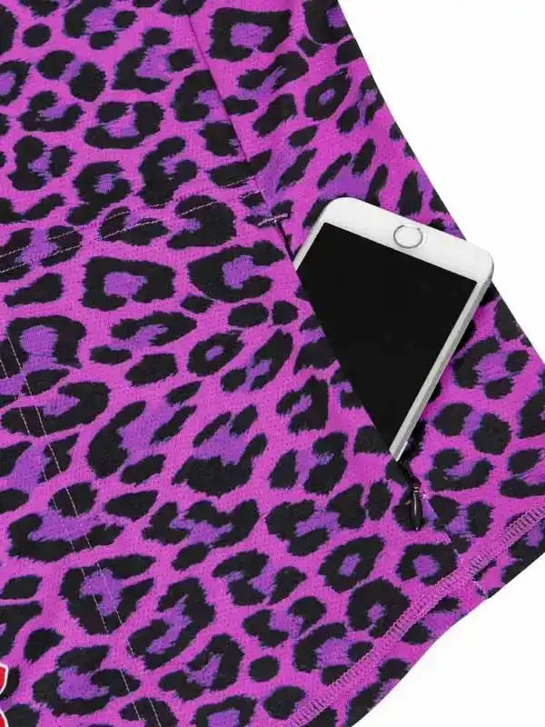 Purple leopard print cycling shorts with zip pocket holding phone