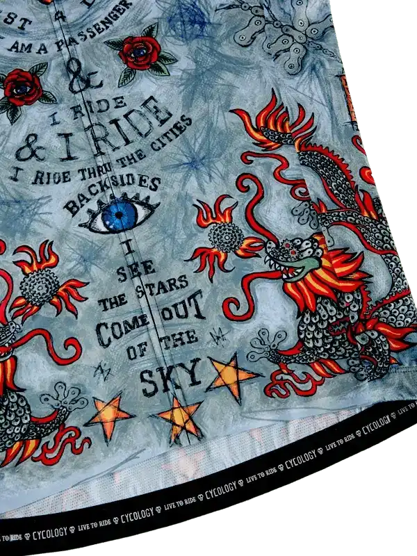 Cycling jersey with dragon, roses, stars, and bold text design on light blue fabric