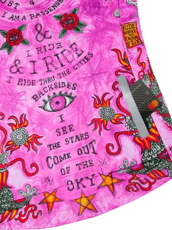 Pink cycling shorts with bold floral, star, and eye graphics, featuring edgy typography for women's bike wear.