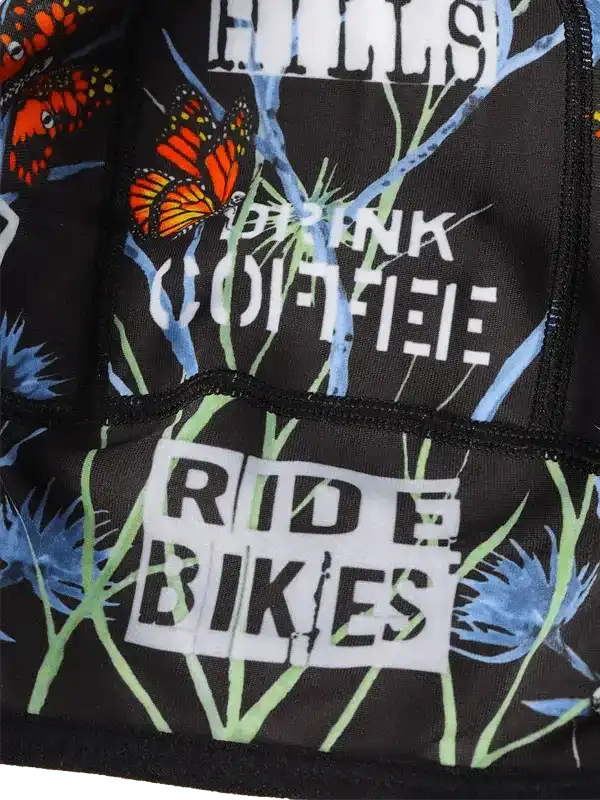 Cycling jersey with butterfly print, 'Drink Coffee Ride Bikes' text, and floral design for bike enthusiasts