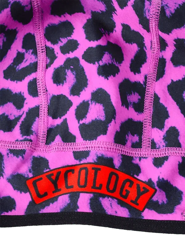 Vibrant pink leopard print cycling jersey with bold red Cycology logo, featuring high-quality seams for performance wear.