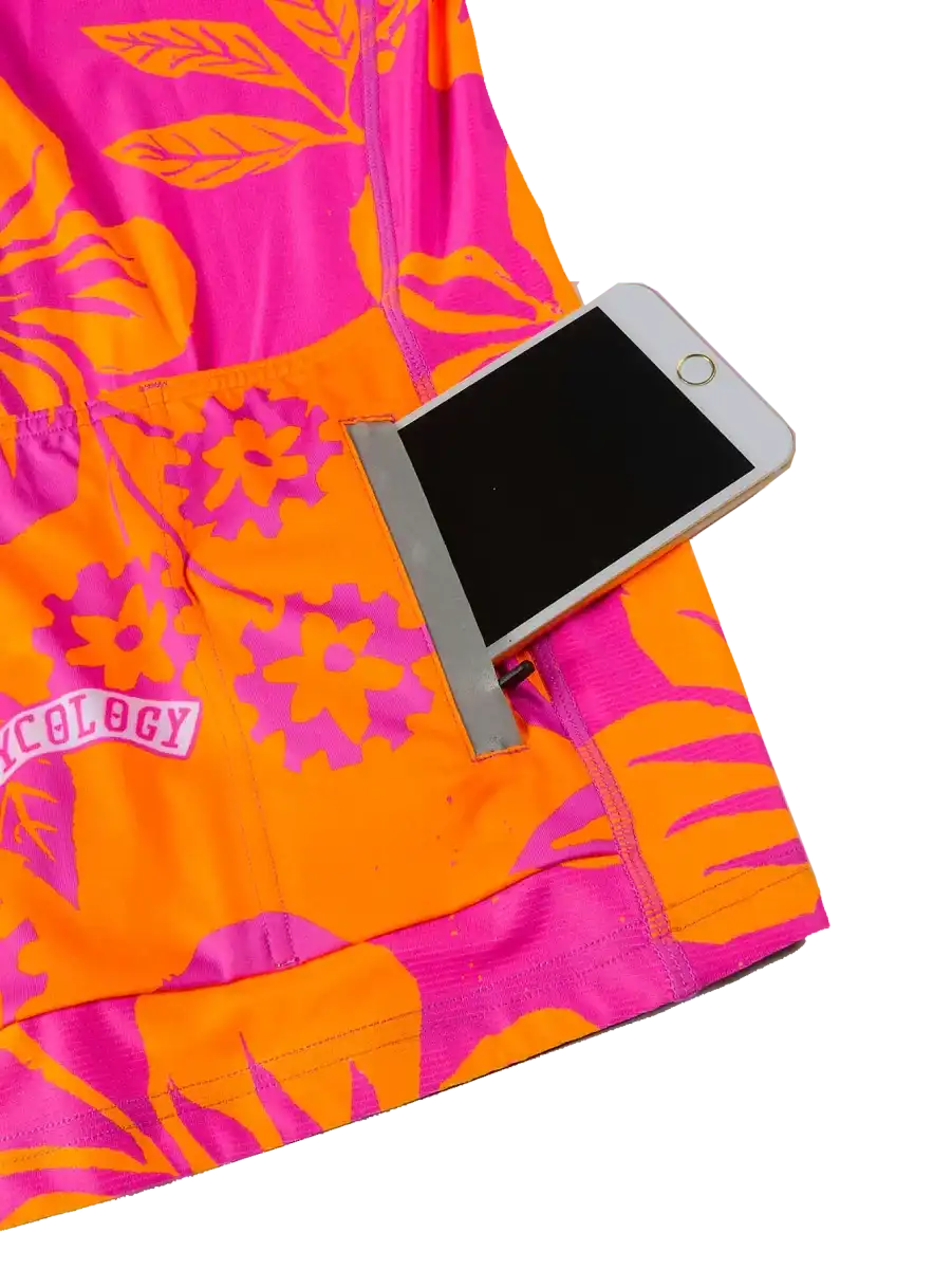 Vibrant pink and orange floral cycling jersey with phone pocket, showcasing functional design for riders.