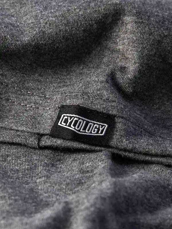 Cycology brand tag on dark gray cycling apparel fabric, showcasing quality stitching and design detail