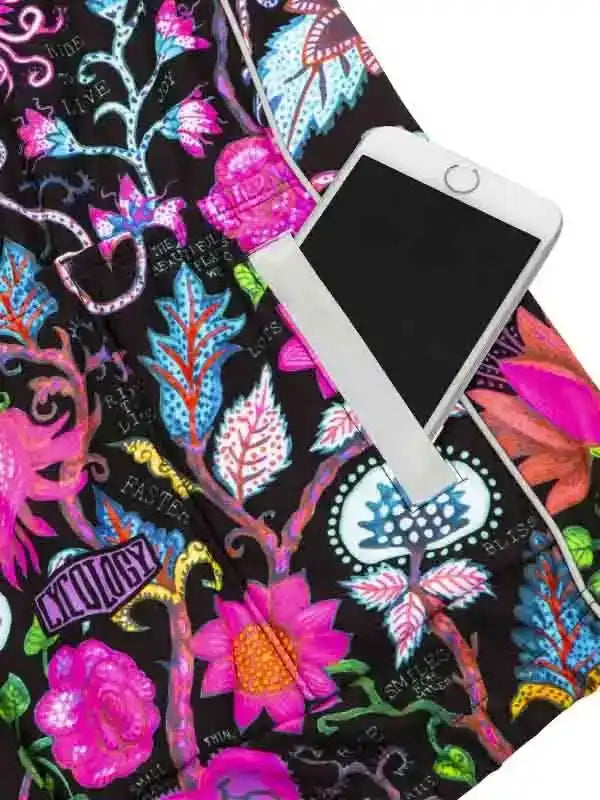 Vibrant floral cycling shorts with phone pocket, featuring bold pink and blue botanical print on black fabric.