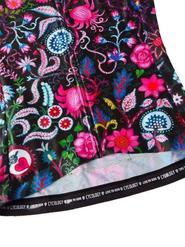 Vibrant floral cycling jersey with pink, blue, and green patterns on black fabric, featuring branded hem.