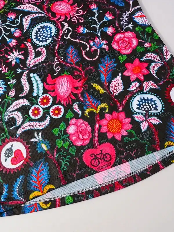 Vibrant floral cycling shorts with pink roses, bike motifs, and bold patterns on black fabric