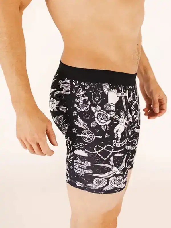 Men's cycling shorts with tattoo-style rose and anchor print, black base, white graphics