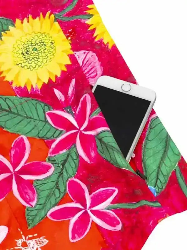 Vibrant floral cycling jersey pocket holding smartphone, featuring sunflowers and plumeria on bright fabric.