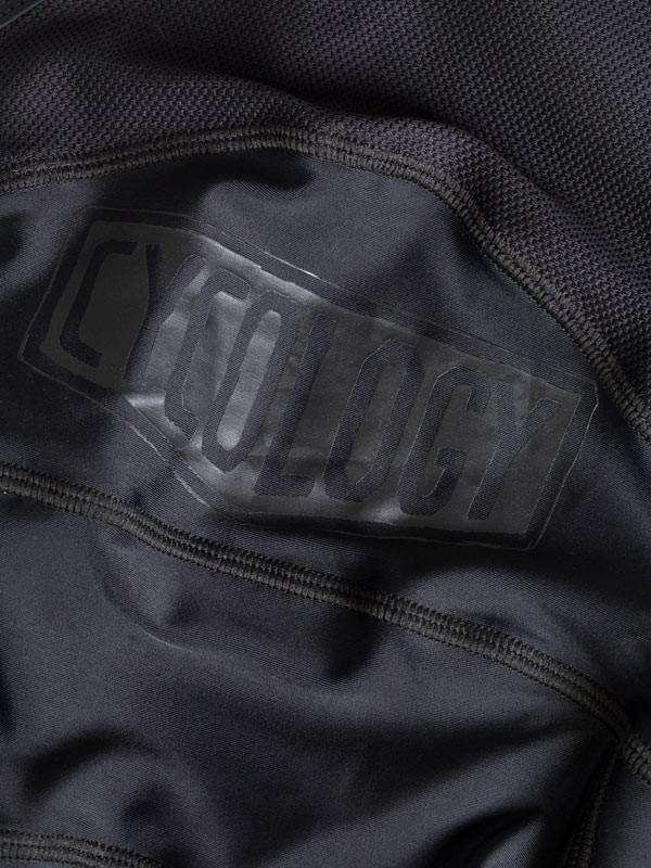 Close-up of black cycling jersey with embossed Cycology logo, showcasing performance fabric texture and design detail.