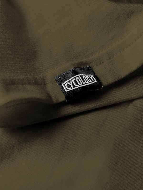 Cycology brand tag on olive green cycling apparel, showcasing quality fabric and design detail