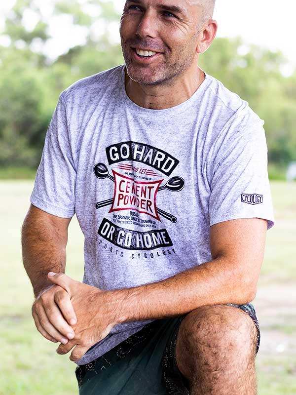 Man wearing gray cycling t-shirt with 'Go Hard or Go Home' graphic, ideal for men's cycling apparel