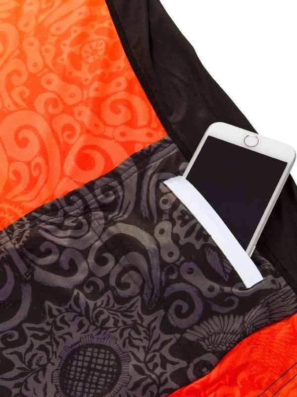 Cycling jersey pocket holding smartphone, orange and black patterned fabric, functional design for riders