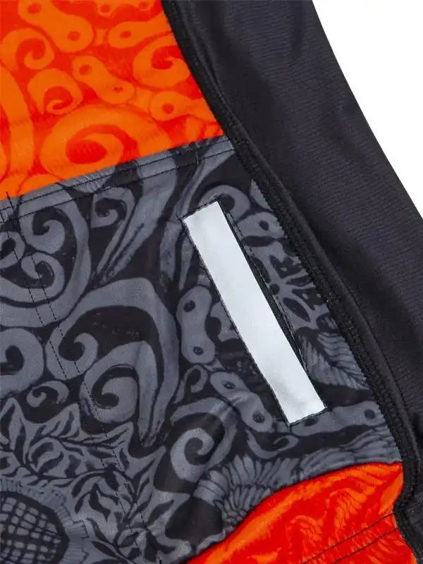 Men's cycling jersey with bold orange and gray swirl pattern, reflective strip, and performance fabric detail