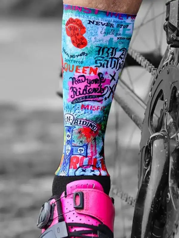 Colorful cycling socks with bold graphics and text, paired with pink bike shoes and a bicycle chain