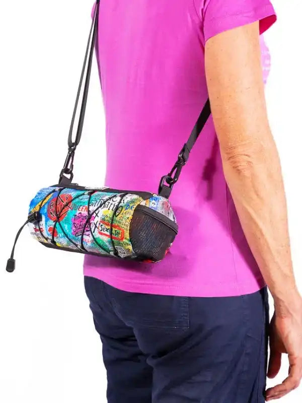 Colorful graffiti-style cycling waist bag with adjustable strap, worn by person in pink shirt
