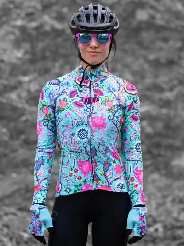 Woman in vibrant floral cycling jersey, helmet, and sunglasses, ready for a ride