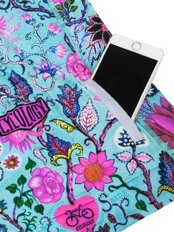 Vibrant floral cycling shorts with phone pocket, featuring bold pink and blue botanical print for women's bike wear.