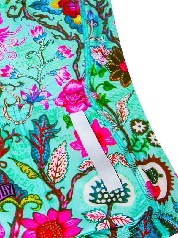Vibrant floral cycling shorts with reflective strip, colorful botanical print on teal fabric