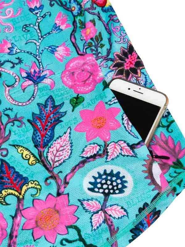Vibrant floral cycling jersey pocket holding smartphone, turquoise base with pink and blue blooms, stylish ride gear