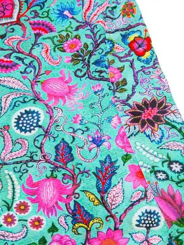 Vibrant floral cycling jersey with pink, blue, and teal botanical print on performance fabric