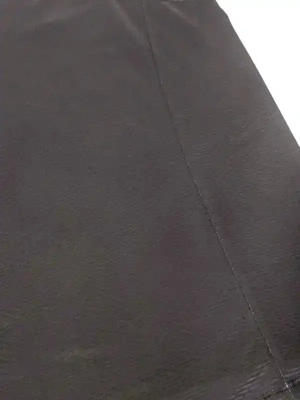Close-up of dark cycling shorts fabric with visible seam detail, showcasing durable material for active wear.
