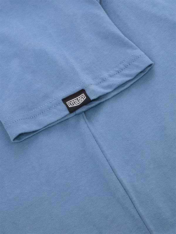 Light blue cycling jersey sleeve with Cycology brand tag, showcasing high-quality fabric and stitching detail