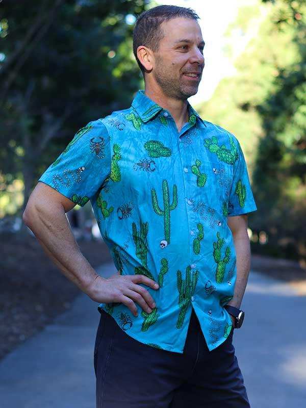 Man wearing blue cactus print short sleeve shirt outdoors, casual cycling apparel design