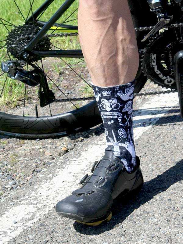 Cycling socks with bike graphics worn with clip-in shoes beside road bike