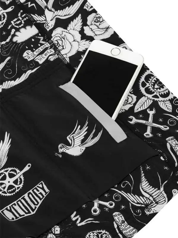Black cycling shorts with white tattoo-style graphics, featuring birds, roses, and bike parts, plus a phone pocket.