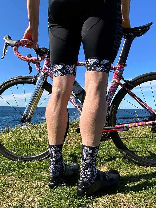 Cycling shorts and patterned socks with road bike by ocean, ideal for men's and women's cycling apparel