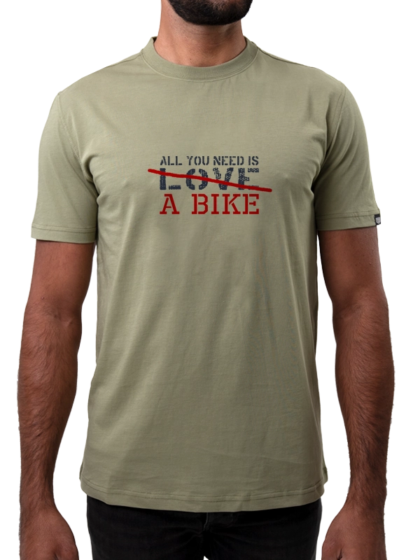 Person wearing a green t-shirt with a printed message All you need is a bike 