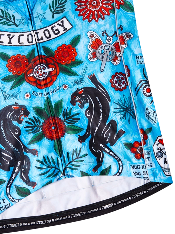 Close-up of a colorful cycling jersey with panther, flower, and butterfly design on a blue background. 