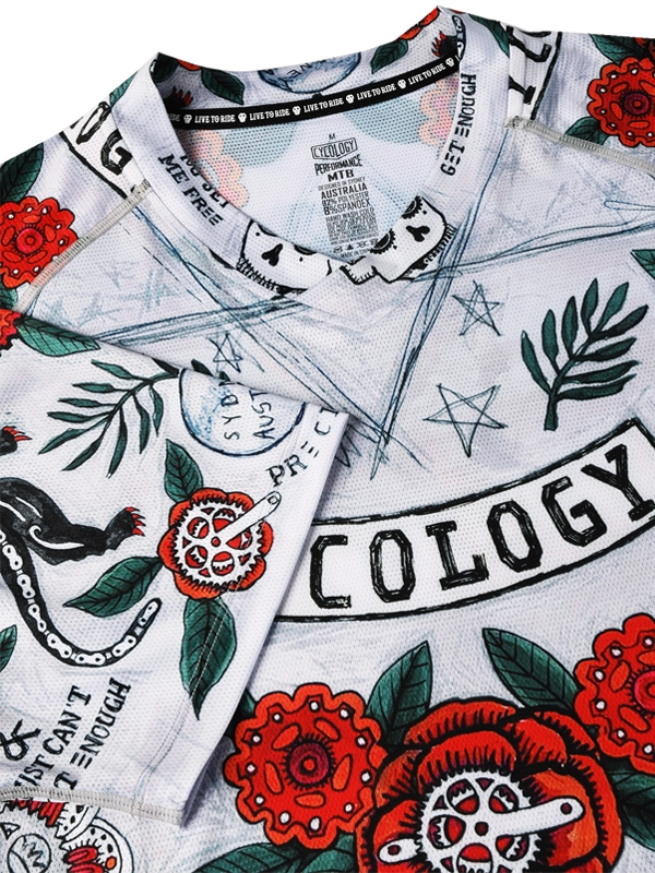 Close-up of a MTB  shirt with tattoo-style designs, including roses and text, V neck
