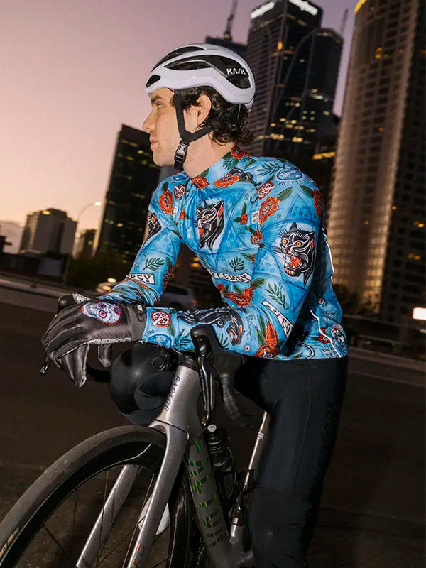 Cyclist wearing a colorful jersey with a cityscape background