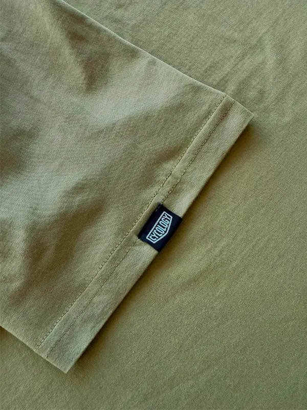 Close-up of a green fabric with a brand label on a matching background