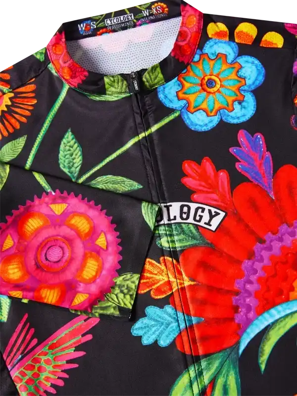 Vibrant floral cycling jersey with bold colors and 'OLOGY' logo, perfect for women's bike rides.