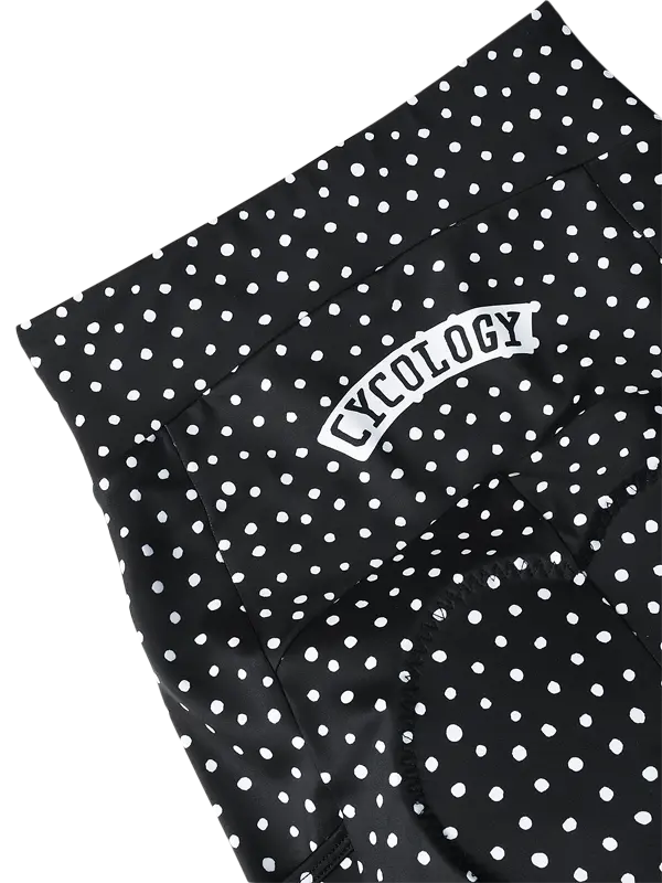 Black and white polka dot fabric with a white arched patch reading 'CYCOLOGY' on a plain white background.